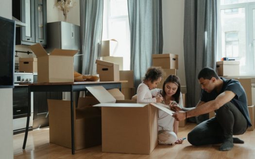Family unpacking boxes in new home.